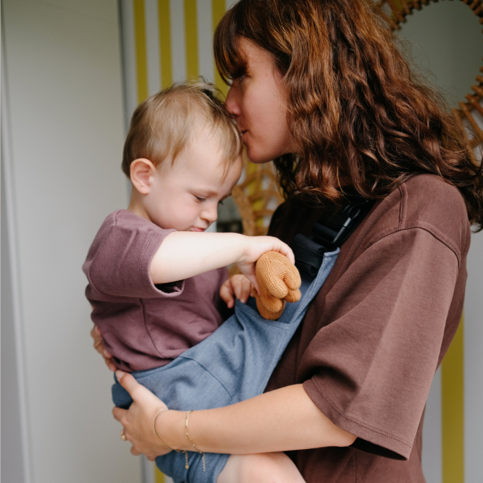 Enfant blotti dans le porte-bébé de hanche