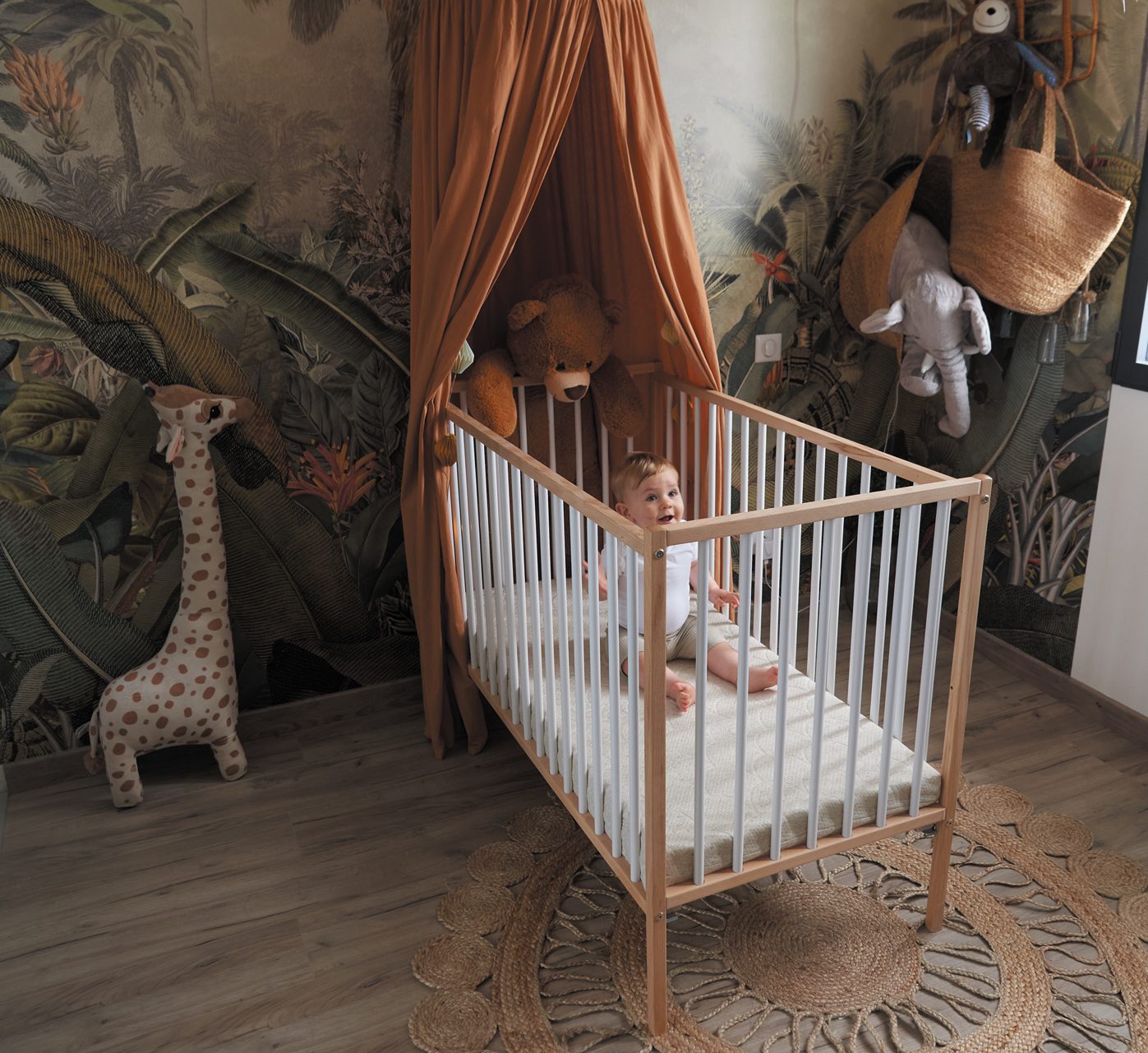 lit en bois dans chambre bébé à la décoration jungle